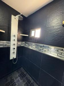 een zwarte badkamer met een douche en een raam bij Hospedaje Dino in Cartagena