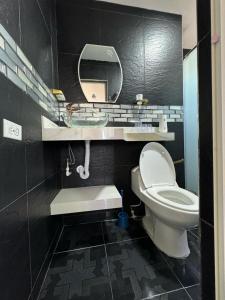 een badkamer met een wit toilet en een spiegel bij Hospedaje Dino in Cartagena