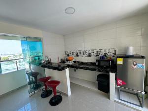 een keuken met een aanrecht en rode krukken. bij Hospedaje Dino in Cartagena