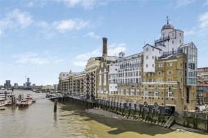 a large building next to a body of water at Subpenthouse sleeps 6, Stunning views of Tower Bridge! in London