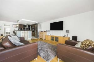 uma sala de estar com 2 sofás e uma televisão de ecrã plano em Subpenthouse sleeps 6, Stunning views of Tower Bridge! em Londres