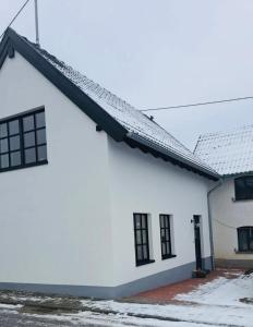 a white building with black windows and a roof at Eifel-Bau-Traum Schlich in Wershofen