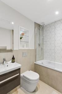 a bathroom with a toilet and a sink and a tub at Stunning 1 Bed Studio Flat With FREE PARKING and FREE WIFI in Capella Court Purley in Purley