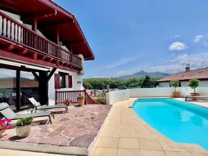 a patio with a swimming pool and a house at Villa Goxoki in Urrugne