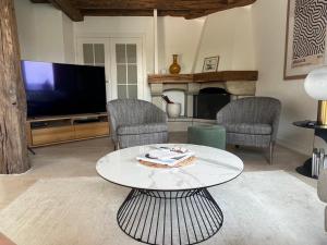 a living room with a tv and a table and chairs at Villa Goxoki in Urrugne