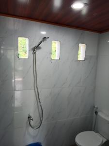 a bathroom with a shower and a toilet at Rammang-Rammang Cottage in Kasijala