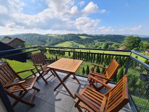 un patio con sedie e un tavolo sul balcone. di OWCZA GÓRKA Apartamenty a Istebna