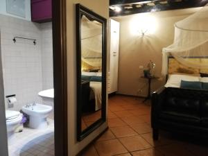 uma casa de banho com um espelho, uma cama e um WC. em Apartments Campo de Fiori em Roma