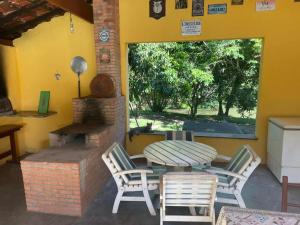 un patio con mesa, sillas y chimenea en Sítio Ipecamirim, en Bragança Paulista