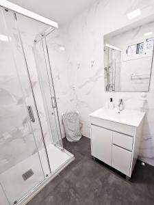 a white bathroom with a shower and a sink at Refugio en el Mar in San Agustin