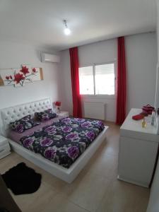 Schlafzimmer mit einem Bett und einem Fenster mit roten Vorhängen in der Unterkunft Palm Lake Ressort Monastir S2 in Monastir