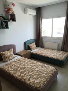 a bedroom with two beds and a window at Palm Lake Ressort Monastir S2 in Monastir