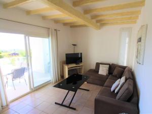 a living room with a couch and a television at LE CLOS BUCCI - Golfe de Saint-Tropez - Les hauts de Grimaud, villa avec vue exceptionnelle in Grimaud