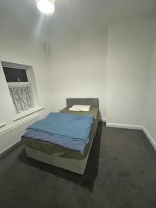 a bedroom with a bed in a white room at Glo Stay @ Hibbert Crescent in Skegby