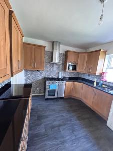 an empty kitchen with wooden cabinets and appliances at Glo Stay @ Hibbert Crescent in Skegby
