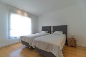 deux lits dans une chambre blanche avec une fenêtre dans l'établissement Mascarat Beach Apartment de Lux, EN52B, à Altea la Vieja 26 autres photos