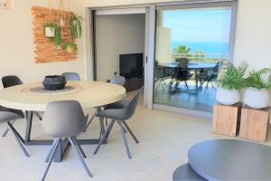 a dining room with a table and chairs and a view of the ocean at Mascarat Beach Apartment de Lux, EN52B in Altea la Vieja