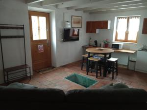 a living room with a table and a kitchen at Maison calme in Vinzelles
