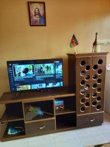 a flat screen tv sitting on top of a entertainment center at Annie's House in Syokimau