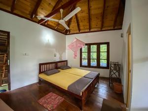 a bedroom with a bed and a ceiling fan at Seasons Four Eco Friendly Cabana MATARA in Matara