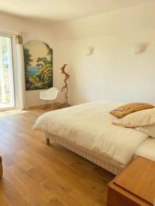 1 dormitorio con 1 cama y una pintura en la pared en Emplacement idéal dans le Var ! en Cuers