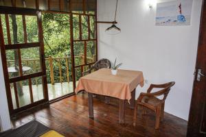a table and chairs in a room with a balcony at Seasons Four Eco Friendly Cabana MATARA in Matara