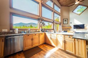 a kitchen with wooden cabinets and a large window at Stunning Views, Luxury, Near Whiteface,Lake Placid in Wilmington