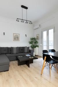 uma sala de estar com um sofá e uma mesa em Olympic Hadrian view apartment! em Atenas