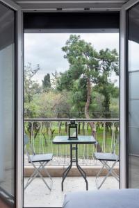 uma vista a partir da varanda de uma casa com uma mesa e cadeiras em Olympic Hadrian view apartment! em Atenas
