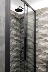 um chuveiro na casa de banho com uma parede de pedra em Olympic Hadrian view apartment! em Atenas