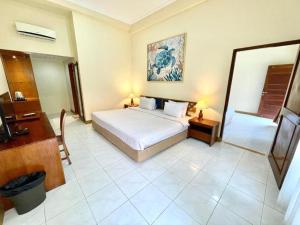 a bedroom with a bed and a television in it at Marine Bay Sanur in Sanur