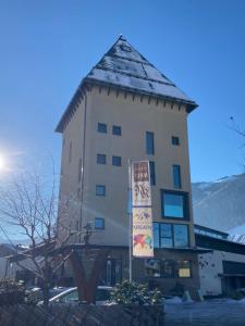 un edificio alto con un cartel delante en Loft im Turm, en Maishofen