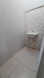 een witte badkamer met een wastafel en een tegelvloer bij VidaBela Lofts Cumbuco CE in Caucaia