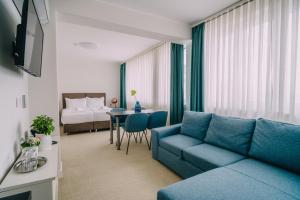 Kul IN Ablana في جابلاناك: غرفة معيشة مع أريكة زرقاء وسرير