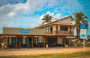 a building on the side of a street with palm trees at Atalaia VIP Praia Hotel in Salinópolis