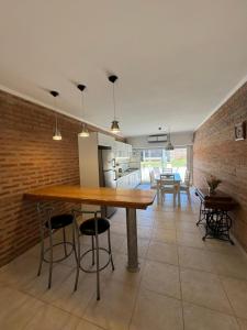 cocina y comedor con mesa de madera y sillas en Casa de playa en Balneario Claromecó