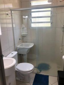 a white bathroom with a toilet and a sink at Apartamento vista pro mar in Tramandaí