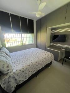 a bedroom with a bed and a tv in it at Apartamento vista pro mar in Tramandaí