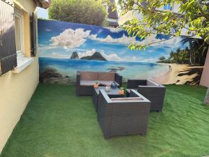 een muur met een muurschildering van een strand bij Studio purple proche Paris in Chennevières-sur-Marne