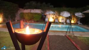 a candle in a chair next to a pool at night at Les Nuits Ourika in Marrakech