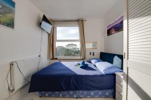 a bedroom with a blue bed and a window at Seaview Central in Portsmouth