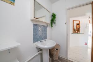 La salle de bains blanche est pourvue d'un lavabo et d'un miroir. dans l'établissement Seaview Central, à Portsmouth