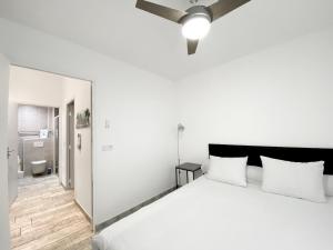 a white bedroom with a large bed and a bathroom at Résidence 4T IMMO - 31 Avenue Gaston Chauvin in Aulnay-sous-Bois
