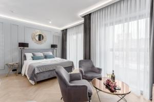 a bedroom with a bed and two chairs and a table at Deo Plaza Premium by Rent like home in Gdańsk