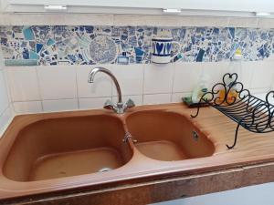 um lavatório de cobre numa cozinha com azulejos azuis e brancos em Domaine de la Borde em Puy-lʼÉvêque