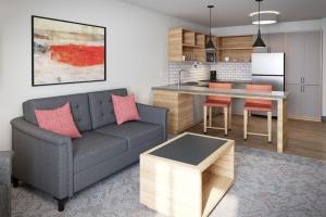 Una sala de estar con un sofá y una cocina. en Candlewood Suites - Corpus Christi - Portland by IHG, en Portland