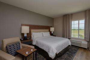 una camera d'albergo con letto e sedia di Candlewood Suites - Corpus Christi - Portland, an IHG Hotel a Portland