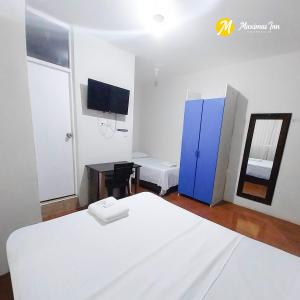 a bedroom with a white bed and a blue cabinet at Maximus Inn in Sechura