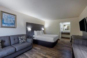 a hotel room with a bed and a couch at Travelodge by Wyndham Florida City/Homestead/Everglades in Florida City +37 photos