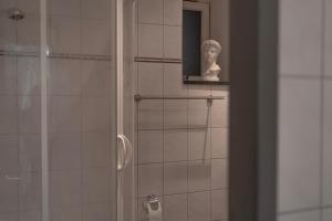 a bathroom with a shower and a statue of a bust at Basement of O in Leipzig +28 photos